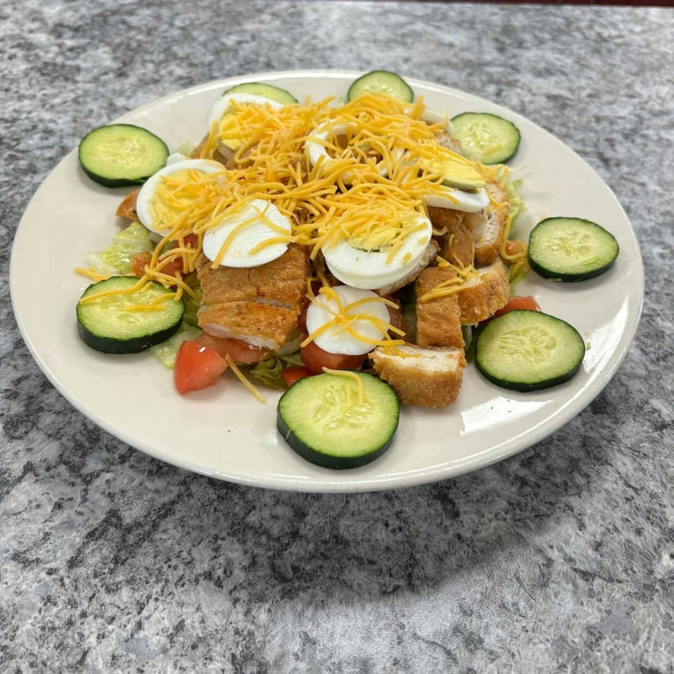 A Broadway FAMILY Grill chicken tender salad with cheese, hard-boiled eggs, and cucumbers.